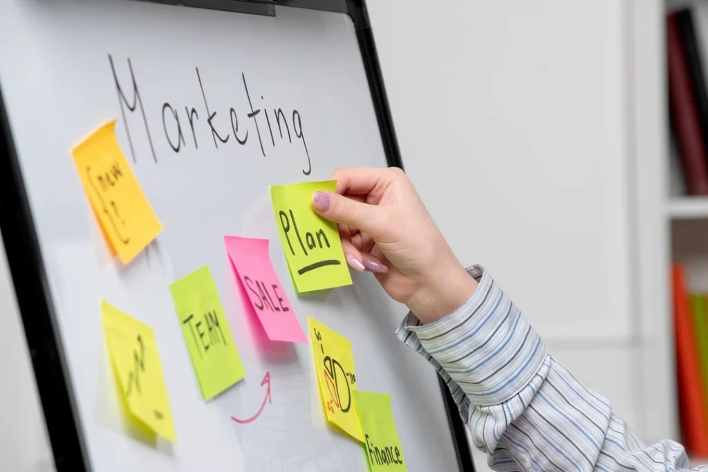 Whiteboard with sticky notes showcasing a marketing plan for business growth.